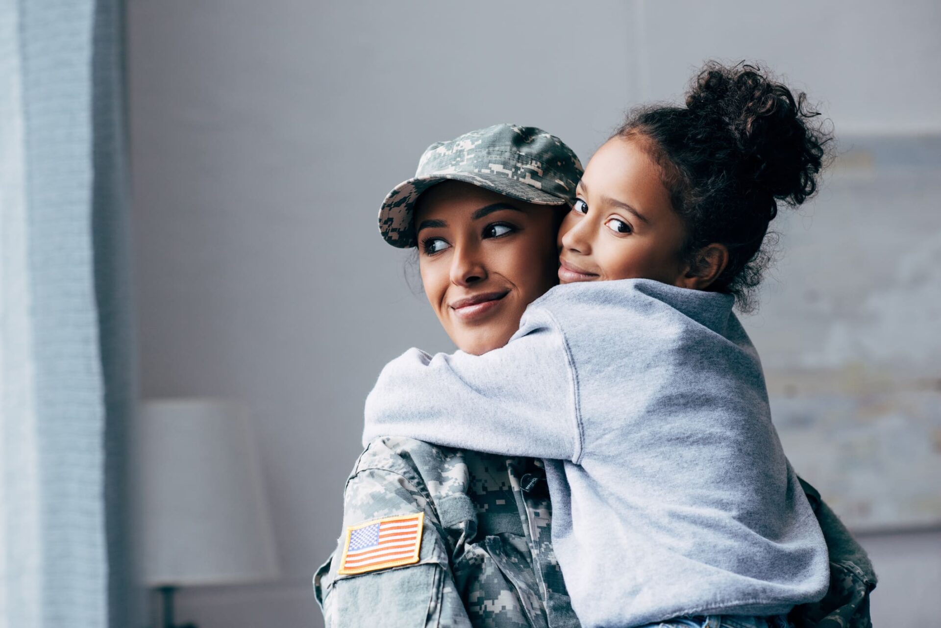 Mamá militar abrazando a una niña