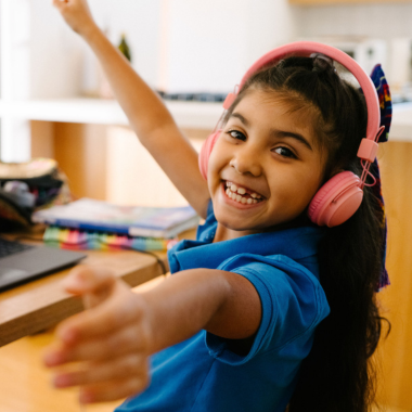 Un alumno de primaria con unos auriculares rosas