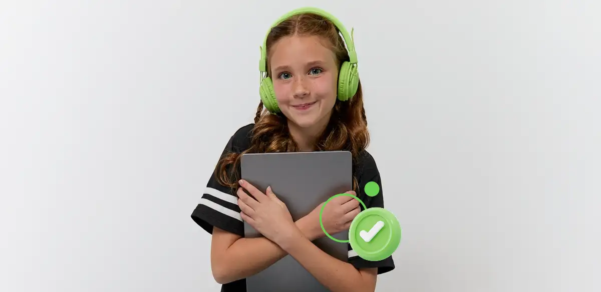 Chica con auriculares verdes sosteniendo una tableta y sonriendo.